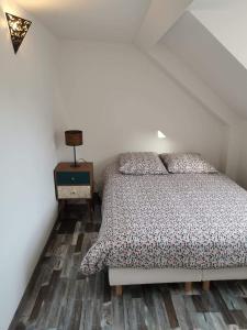 um quarto com uma cama e piso em madeira em La Belle Etaploise em Étaples
