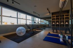um ginásio com uma grande bola e esteiras de ioga em Hotel Darolt Criciúma em Criciúma