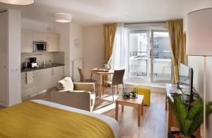 una camera con letto, una cucina e un soggiorno di DOMITYS Les Mosaïques a Rouen