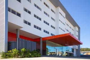 un edificio de oficinas con una fachada roja y blanca en Hotel Darolt Criciúma, en Criciúma