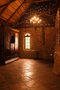 an empty room with a chandelier and a window at Rain Farm Game Lodge in uMhlali