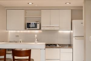 羅薩里奧的住宿－Carat Apart Boutique，白色的厨房配有水槽和微波炉