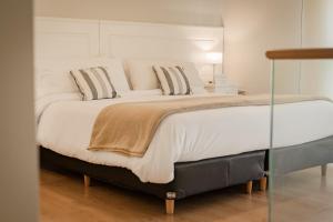 a large bed with white sheets and pillows at Hotel Carat Apart Boutique in Rosario
