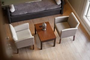 Carat Apart Boutique في روزاريو: غرفة معيشة مع كرسيين وطاولة وأريكة