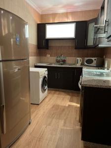 a kitchen with a refrigerator and a washer and dryer at Ronza Elegant Apartment in Amman