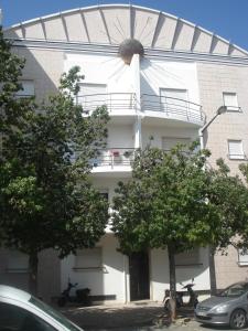 een wit gebouw met bomen ervoor bij Apartamento Tavira in Tavira