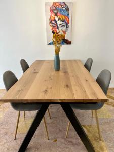 a wooden table with a vase of flowers on it at Amplio y luminoso apartamento en el centro in Don Benito