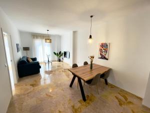 a living room with a wooden table and chairs at Amplio y luminoso apartamento en el centro in Don Benito