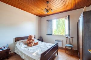 un osito de peluche sentado en una cama en un dormitorio en Maison de 2 chambres avec jardin clos a Eymet, en Eymet