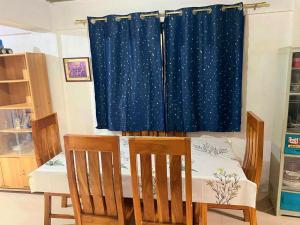 a room with a table and chairs and a curtain at Eastdee Homestay - Aircon Room 108 in Lidlidda