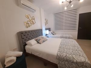 1 dormitorio con 2 camas y ventana en Relax Habitación Privada, en Manta