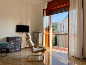 a living room with a chair and a large window at Casa Berizzi - Santa Lucia in Bergamo