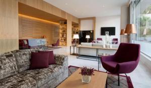 a living room with a couch and a table at Avani Avenida Liberdade Lisbon Hotel in Lisbon