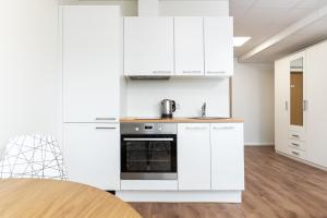 a kitchen with white cabinets and a stove at LKS Apartment one in Tallinn +6 photos