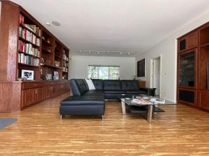 ein Wohnzimmer mit einem schwarzen Ledersofa und einem Tisch in der Unterkunft The Gaard House in Carlton