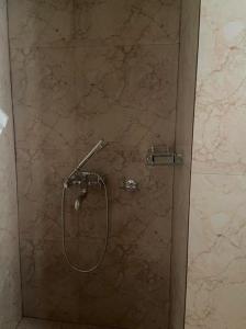um chuveiro na casa de banho com uma parede de pedra em Norbus Homestay em Darjeeling