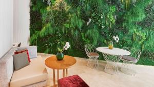 a living room with a green wall with a table and chairs at NH Collection Marseille in Marseille