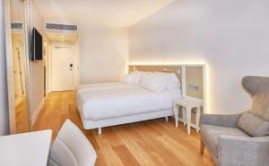 a bedroom with a white bed and a couch at NH Collection Marseille in Marseille