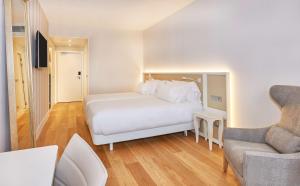 a bedroom with a white bed and a couch at NH Collection Marseille in Marseille