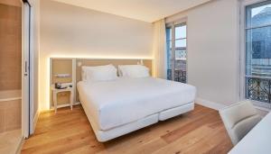 a bedroom with a large white bed and a window at NH Collection Marseille in Marseille