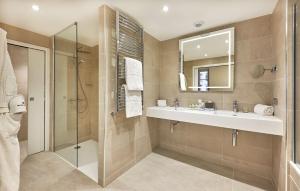 a bathroom with a shower and a sink and a mirror at NH Collection Marseille in Marseille