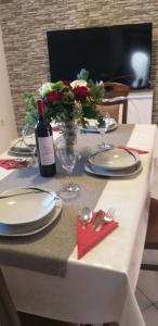 a table with plates and glasses and a bottle of wine at Apartman Blazenka in Viskovo