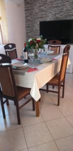 a dining room table with a white tablecloth and chairs at Apartman Blazenka in Viskovo
