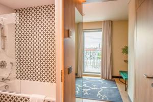 a bathroom with a shower and a glass door with a window at NH Porto Jardim in Porto