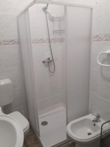 een badkamer met een douche, een toilet en een wastafel bij Aconchego Alojamento Local in Nazaré