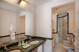 a bathroom with two sinks and a large mirror at NH Lecco Pontevecchio in Lecco