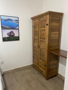um quarto com um armário de madeira ao lado de uma parede em Aruanã Suite Green em Vila Velha