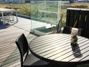 une terrasse en bois avec une table, des chaises et un pot dans l'établissement 9 person holiday home in Thisted, à Nørre Vorupør