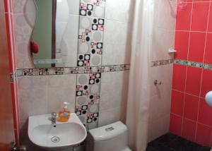ein Badezimmer mit einem WC, einem Waschbecken und einem Spiegel in der Unterkunft LUANA’S HOUSE in Ica