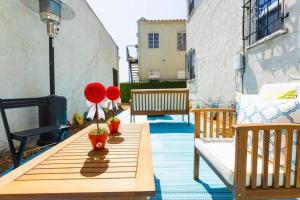 a wooden table with red flowers on a patio at Charming LA 2 Bedroom For Your Home Away From Home in Los Angeles