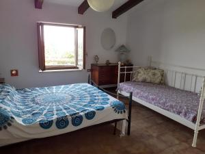 a bedroom with two beds and a window at Villa Ambra in Vigolo