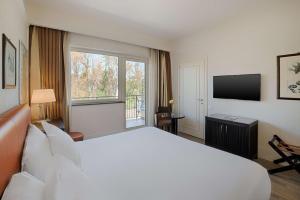 a hotel room with a large bed and a television at NH Catania Parco degli Aragonesi in Catania