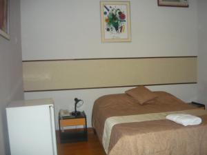 a bedroom with a bed and a table with a lamp at SAFARI HOTEL IQUITOS in Iquitos