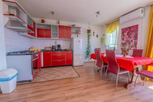 a kitchen with red cabinets and a table with chairs at Cozy apartments with sea view in Novi Vinodolski