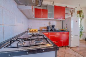 a kitchen with red cabinets and a stove top oven at Cozy apartments with sea view in Novi Vinodolski