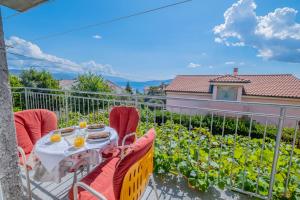 a table and chairs on the balcony of a house at Cozy apartments with sea view in Novi Vinodolski