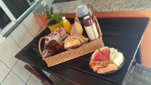 a table with a basket of food on a table at Pousada Flores de Bombinhas in Bombinhas