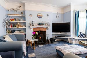 a living room with a fireplace and a tv at Finest Retreats - Hillview House in Minehead