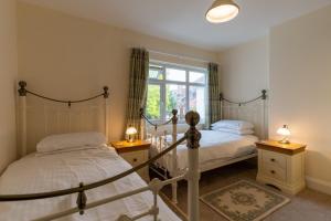 a bedroom with two beds and a window at Finest Retreats - Hillview House in Minehead