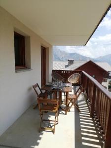 uma varanda com uma mesa e cadeiras em Espace et confort dans station familiale à 1800 m em Puy-Saint-Vincent