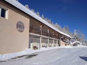 a building with snow on the ground in front of it at Babaute 7, studio typique au pied des pistes in Prémanon