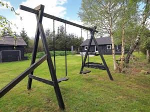 an empty swing set in a yard with a house at 6 person holiday home in Hals in Hals