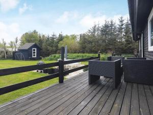 a wooden deck with two benches and a fence at 6 person holiday home in Hals in Hals