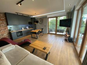 a living room with a couch and a table at Apartament Grey Love w Czeladzi, FV, 8km do Katowic in Czeladź