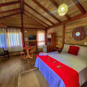 Cette chambre en bois comprend un grand lit. dans l'établissement Pousada & Camping Nativos dos Canyons, à Praia Grande