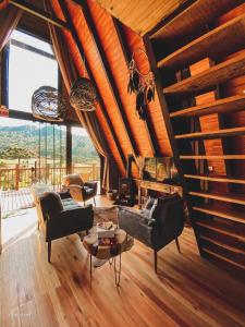 uma sala de estar com tectos em madeira e uma grande janela em Estância Nazari em Urubici